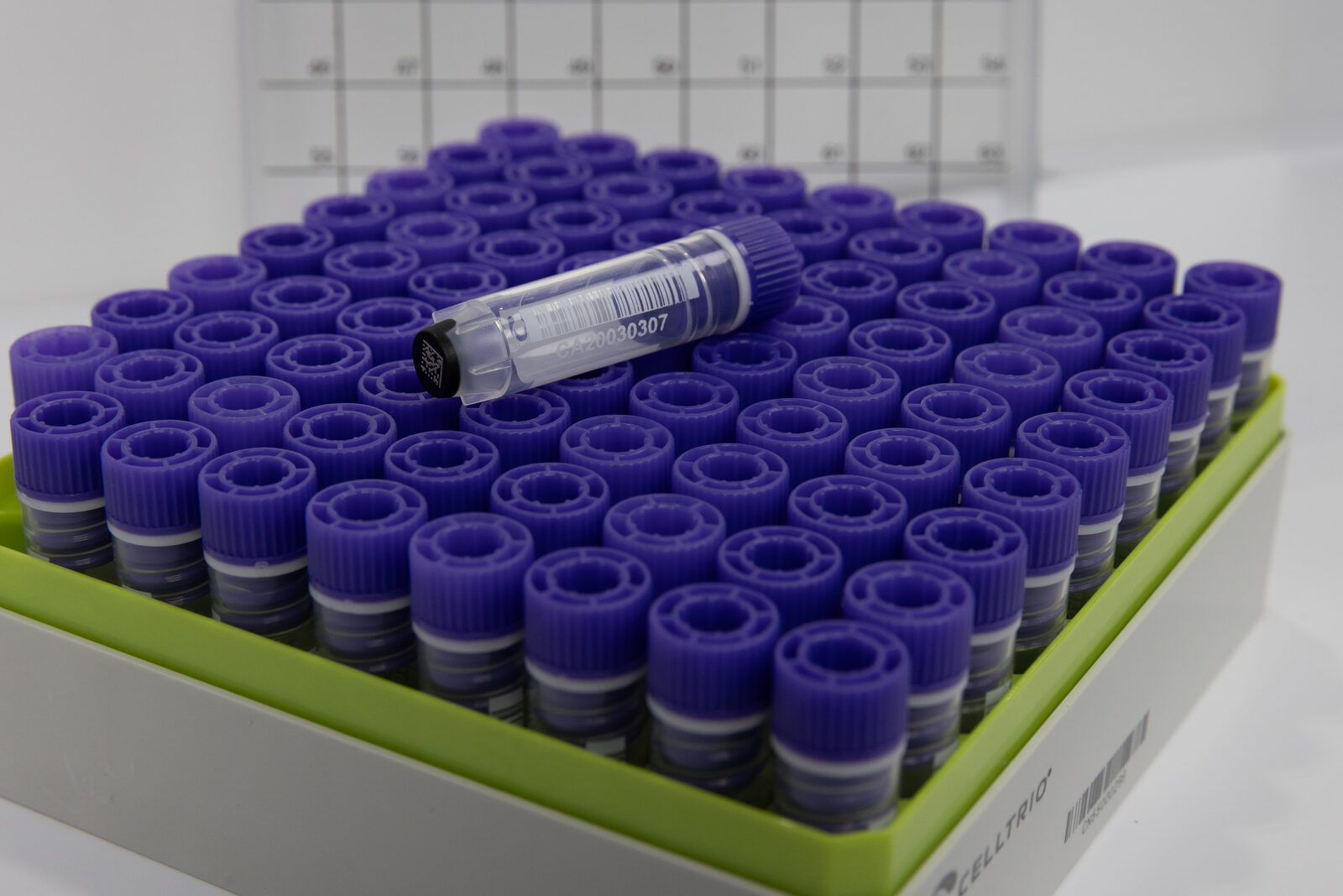 Celltrio cryovial with a 1D side barcode and a 2D code on the base, on a rack of cryovials